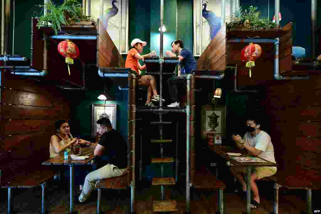 People sit at Lhong Tou cafe during lunch time in the Chinatown area of Bangkok.
