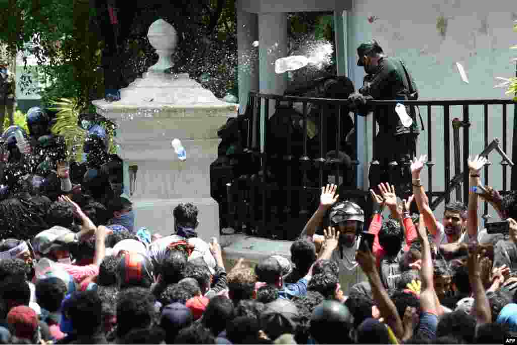 Demonstrators throw bottles of water to army personnel during an anti-government protest outside the office of Sri Lanka's prime minister in Colombo, July 13, 2022. Thousands of anti-government protesters stormed into Prime Minister Ranil Wickremesinghe's office, hours after he was named as acting president, witnesses said. 