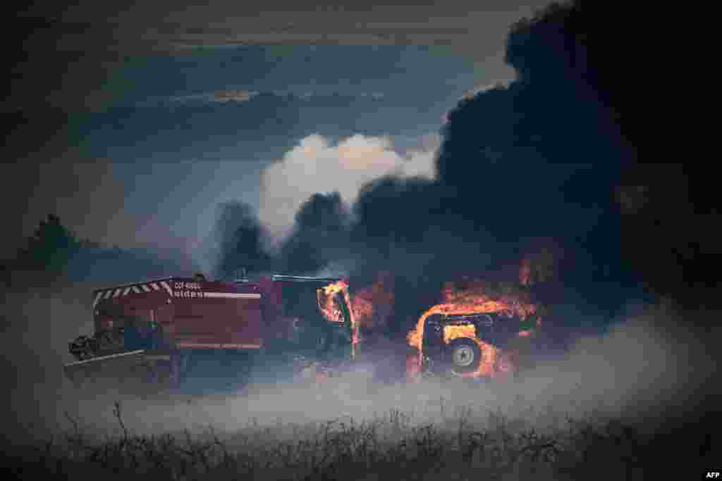 Firefighter trucks are seen burning amid a wildfire on Mont d'Arrees, outside Brasparts, France.