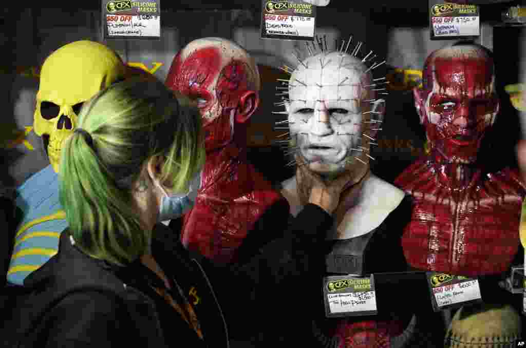 Jenn Brown of CFX (Composite Effects) adjusts a silicon mask from the movie franchise "Hellraiser" during Preview Night at the 2022 Comic-Con International at the San Diego Convention Center, in San Diego, California, July 20, 2022.