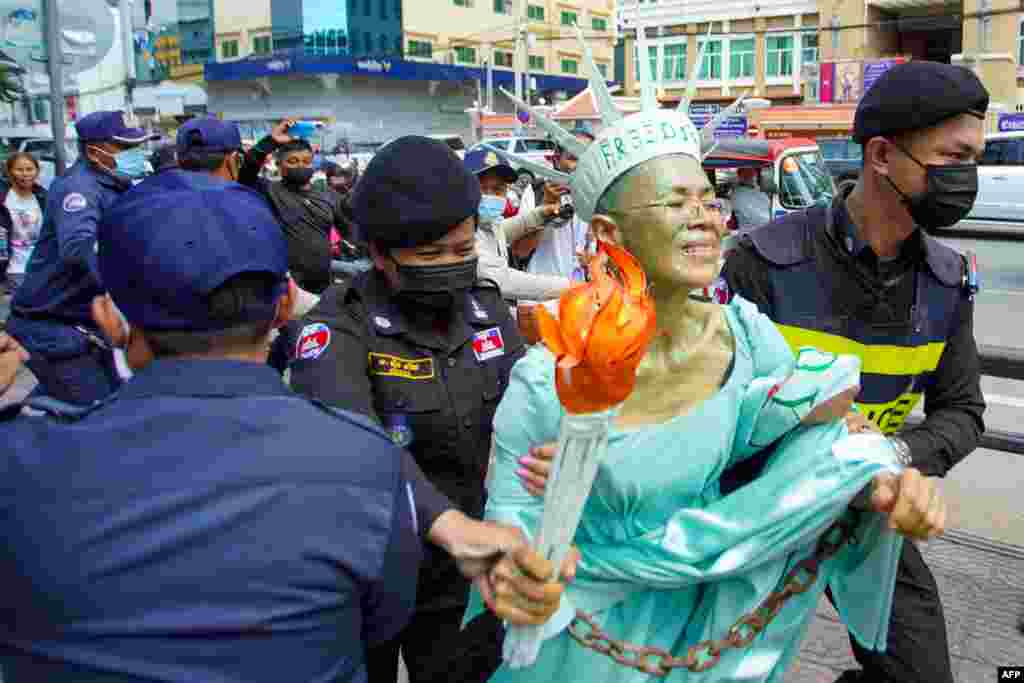 Cambodian-U.S. human rights advocate Theary Seng, dressed as Lady Liberty, is arrested by police in front of the Phnom Penh municipal court. A Cambodian court handed down jail sentences to about 60 opposition figures including Theary Seng for conspiring to commit treason, in a mass trial condemned by the United States and rights groups as politically motivated.