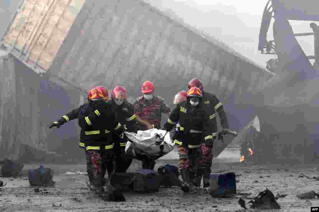 Firefighters carry the dead body of a victim from the site after a fire broke out at a container storage facility in Sitakunda, about 40 km (25 miles) from the key port of Chittagong, Bangladesh. At least 49 people were killed and hundreds more were injured, officials said.