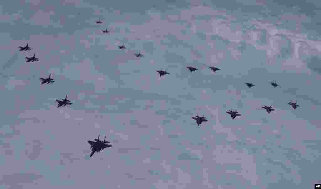 In this photo provided by South Korea Defense Ministry, U.S. and South Korean fighter jets fly in formation over South Korea's western sea during a joint drill.