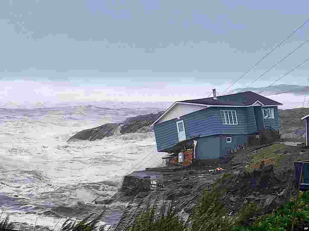 In this photo provided by Wreckhouse Press, a home is hit with high winds caused by post Tropical Storm Fiona in Port aux Basques, Newfoundland and Labrador, Sept. 24, 2022. The home has since been lost at sea.