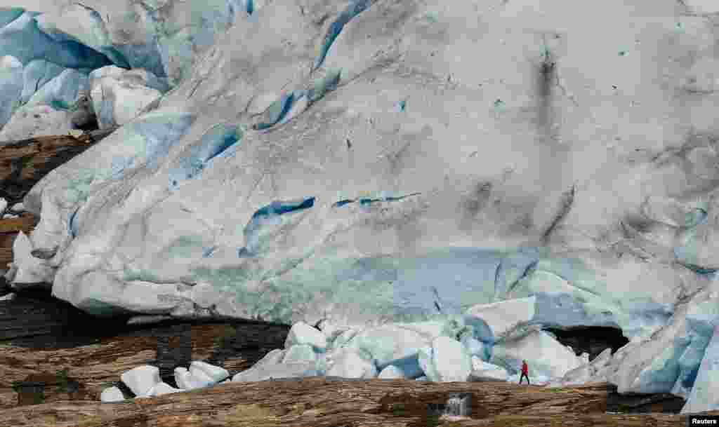 A hiker stands in front of Austerdalsisen, the south side of the inland part of Svartisen glacier, one of Norway's largest glaciers near Mo i Rana, Sept. 19, 2022.