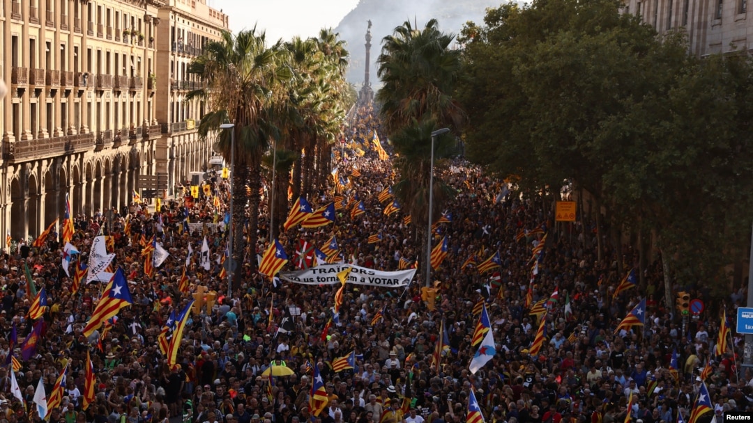 People hold up Esteladas, or Catalan separatist flags, during a demonstration to mark Catalonia's national day 'La Diada' in Barcelona, Spain, Sept. 11, 2022. The banner reads "Independence". 