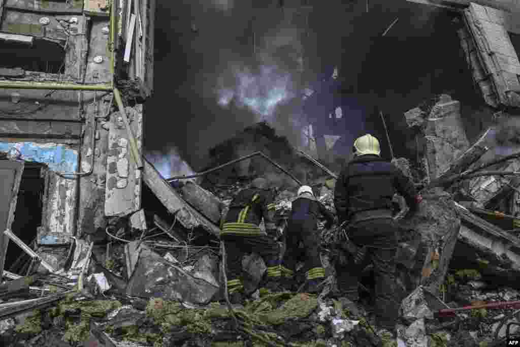Firefighters extinguish a fire after a flat was hit by a missile strike in Bakhmut, Donetsk region, Ukraine.