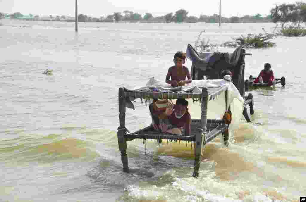 People are seen surrounded by floodwaters, in Sohbat Pur city, a district of Pakistan's southwestern Baluchistan province, Sept. 3, 2022.