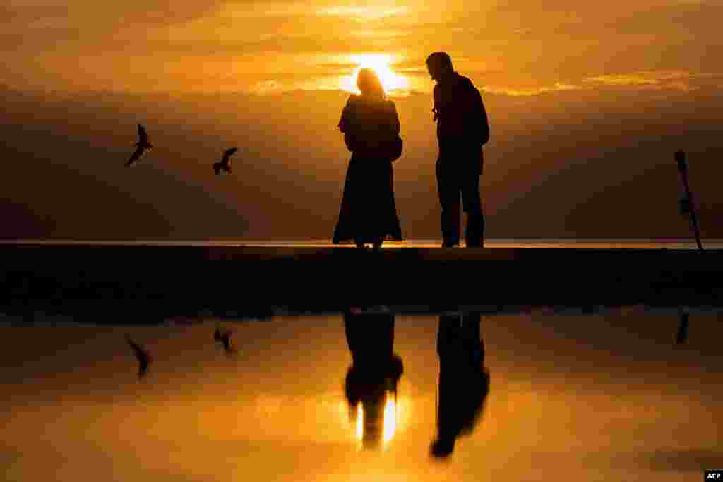 People look at the sunset on the beach of Deauville, France, Sept. 4, 2022.