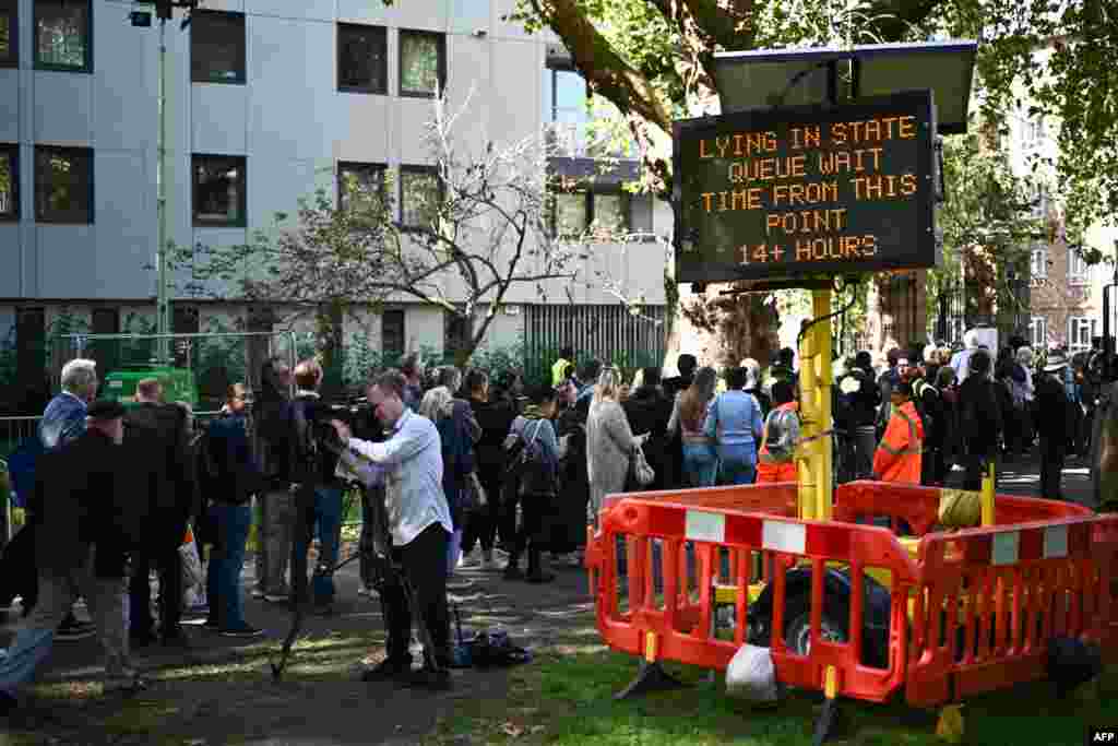 A digital sign board displays the queuing time at Southwark Park, as people wait in line to pay their respects to the late Queen Elizabeth II, in London.