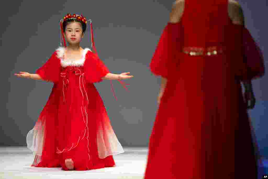 A model presents a creation in the kidswear line by Chinese designer Wang Cong in their Jinshangyuyi collection during the China Fashion Week in Beijing.