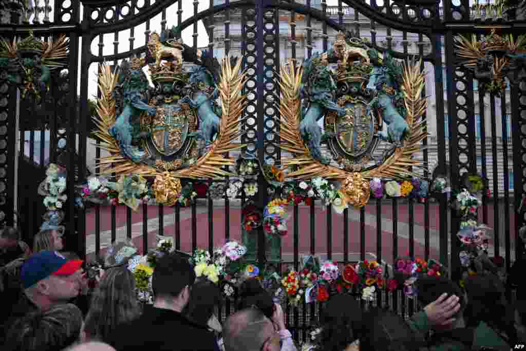 People lay flowers on the gate of Buckingham Palace in central London after it was announced that Queen Elizabeth II has died, in central London on Sept. 8, 2022.