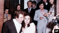FILE - In this 1970 file photo, British actor Albert Finney embraces his bride, French Actress Anouk Aimee, after their registry office wedding in London.