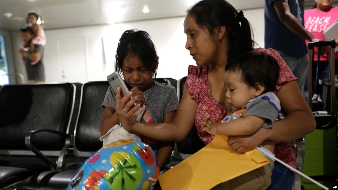 Buena Ventura Martin-Godinez, center, holds her son Pedro, right, as she is reunited with her daughter Janne, left, at Miami International Airport, July 1, 2018, in Miami, Florida. Martin crossed the border into the United States from Mexico in May with her son, fleeing violence in Guatemala. Her husband crossed two weeks later with their 7-year-old daughter Janne. All were caught by the Border Patrol, and were separated. Her daughter was released earlier from a child welfare agency in Michigan.