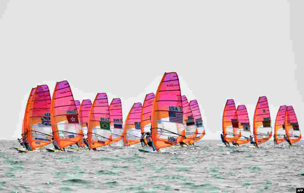 Athletes take part in the women's windsurfing RS:X class competition during a sailing test event for the Tokyo 2020 Olympic Games, off the coast Enoshima in Kanagawa Prefecture, Japan.