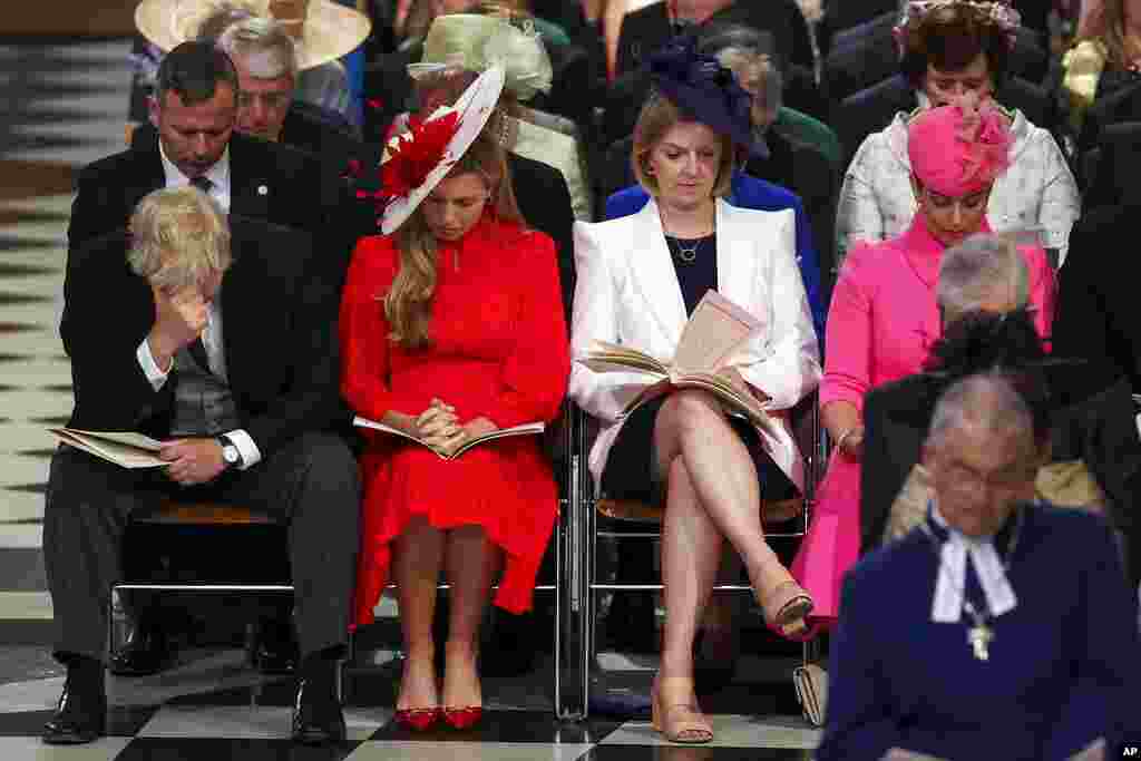 British Prime Minister Boris Johnson, right, reacts as he sits next to his wife, Carrie Johnson, at the National Service of Thanksgiving held at St Paul's Cathedral as part of celebrations marking the Platinum Jubilee of Britain's Queen Elizabeth II, in London.