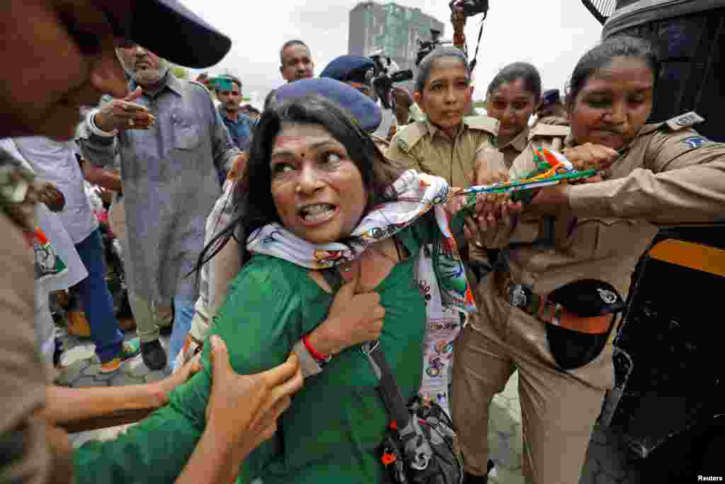 A supporter of India's main opposition Congress party reacts as she is detained by police during a protest after the party leader Rahul Gandhi was summoned by the Enforcement Directorate in a money laundering case, in Ahmedabad.