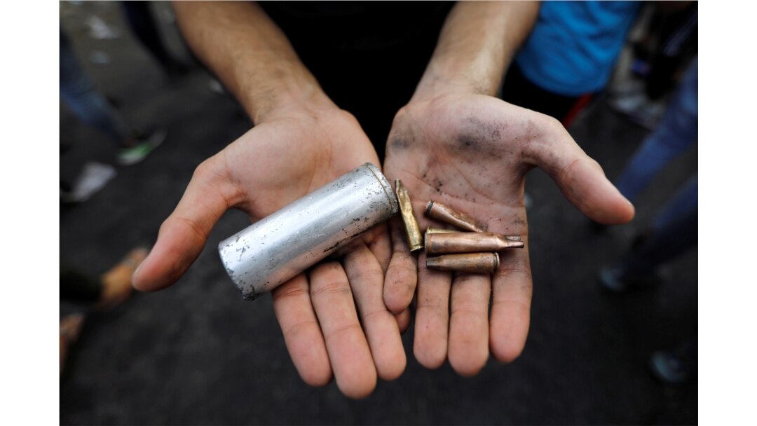 A demonstrator shows empty canisters that were used by Iraqi security forces during a protest over unemployment, corruption and poor public services, in Baghdad, Iraq, Oct. 2, 2019.