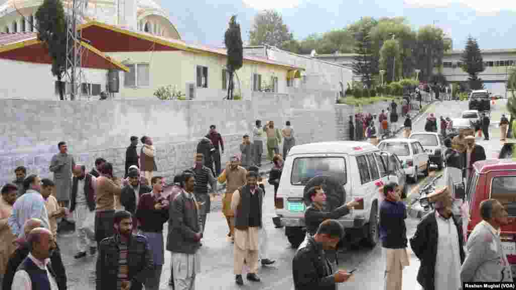 Earthquake-shaken Kashmiris gather outside their offices in Muzaffarabad after a 7.5-magnitude temblor rattled Pakistan and Kashmir. 