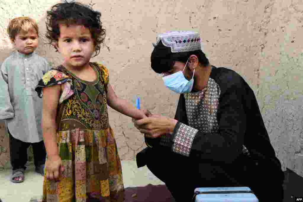 A health worker marks a child's finger with ink after giving polio vaccine at a campaign in Kandahar, Afghanistan.