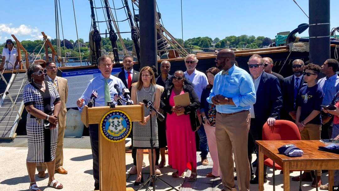Durante una ceremonia frente a la réplica del barco de esclavos Amistad, el gobernador de Connecticut, Ned Lamont, habla el 10 de junio de 2022 en New London, Connecticut, antes de firmar una copia de la legislación que establece un nuevo feriado estatal legal el 19 de junio que se conocerá como el Día de la Emancipación, Juneteenth.