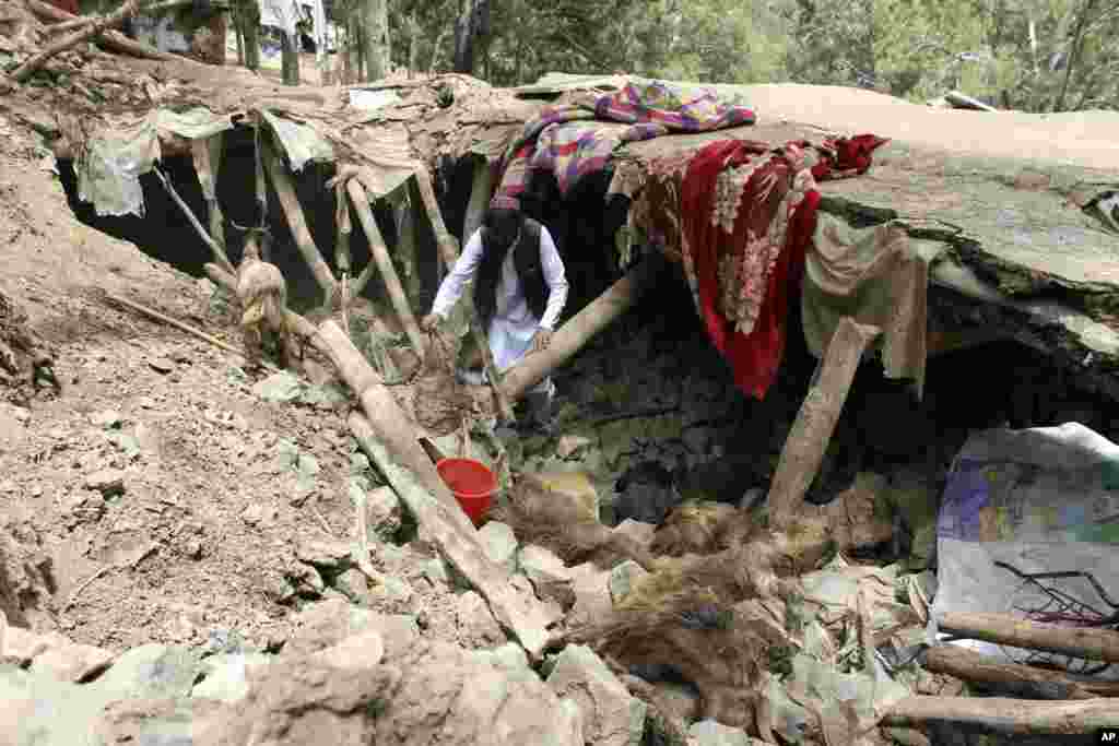 A villager collects his belongings under the rubble of his home that was destroyed in an earthquake in the Spera District of the southwestern part of Khost Province, Afghanistan.