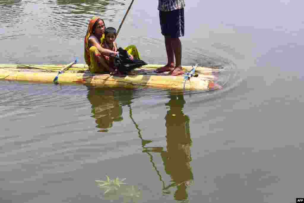Villagers travel on a makeshift raft in flood waters of Hatibhangi village in the Morigaon district, in India's Assam state.