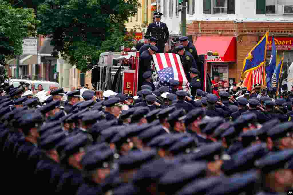 The remains of Lt. Sean Williamson, a 27-year veteran of the Philadelphia Fire Department, are brought to Epiphany of Our Lord Catholic Church for funeral mass in Philadelphia, Pennsylvania. Williamson was killed in an early morning building collapse on June 18.