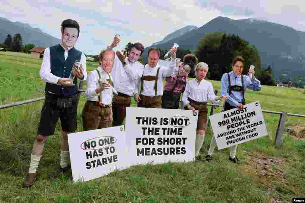 Activists of the NGO ONE, wearing masks depicting G-7 leaders, protest the G-7 summit to be held in the nearby Bavarian alpine resort hotel Elmau Castle, in Garmisch-Partenkirchen, Germany.