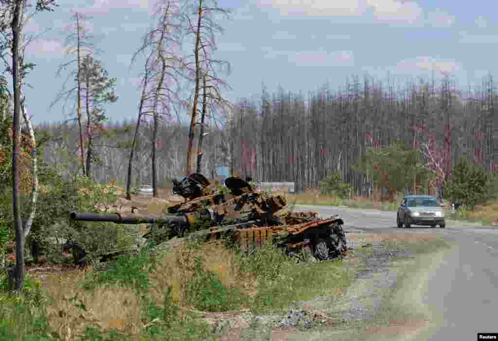 A destroyed tank sits alongside a road outside the city of Sievierodonetsk in the Luhansk Region, Ukraine.