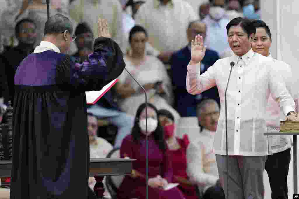 President-elect Ferdinand "Bongbong" Marcos Jr., right, is sworn in by Supreme Court Chief Justice Alexander Gesmundo during the inauguration ceremony at National Museum in Manila, Philippines.