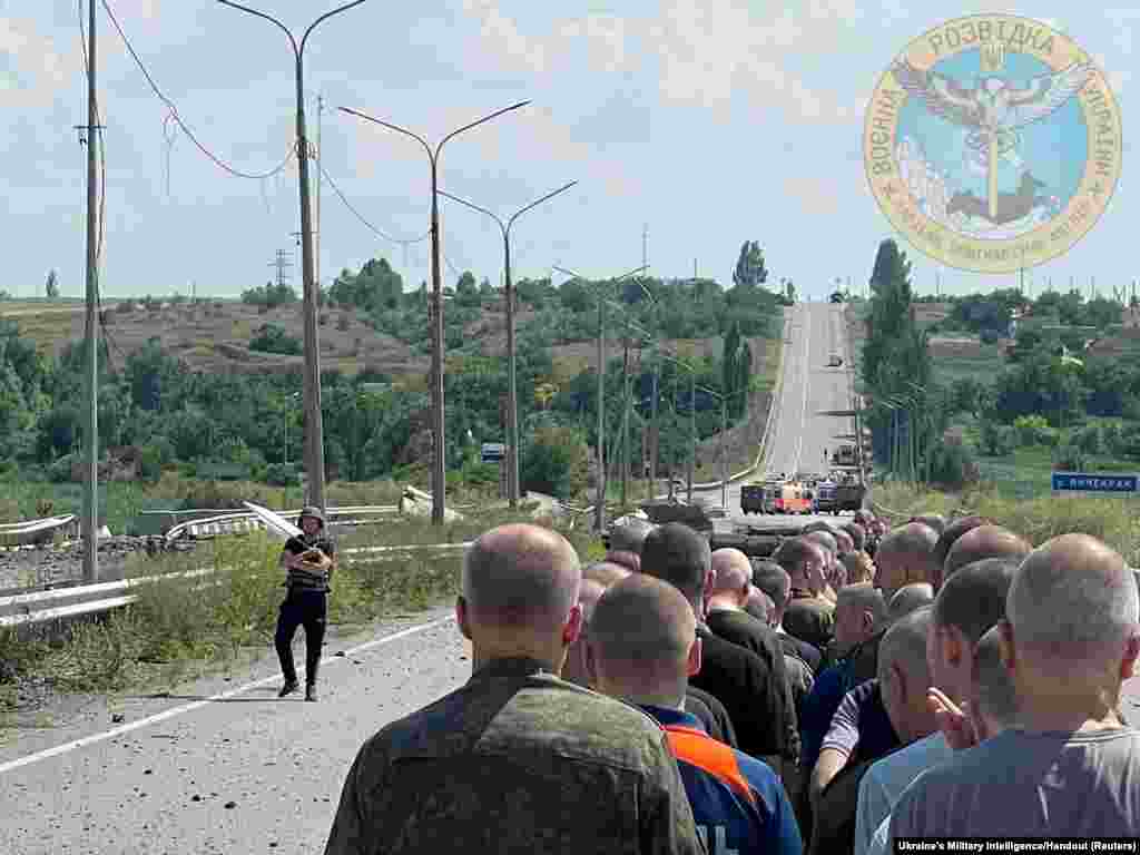 A man with a white flag walks along the road during an exchange of prisoners at a location given as Zaporizhzhia region, Ukraine as Russia's attack on Ukraine continues, June 29, 2022.