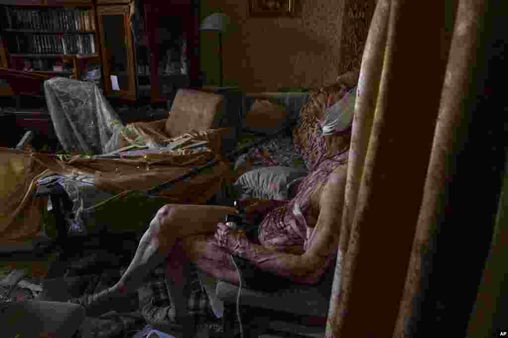 Sixty-six-year-old Volodymyr, injured from a strike, sits on a chair in his damaged apartment, in Kramatorsk, Donetsk region, eastern Ukraine.