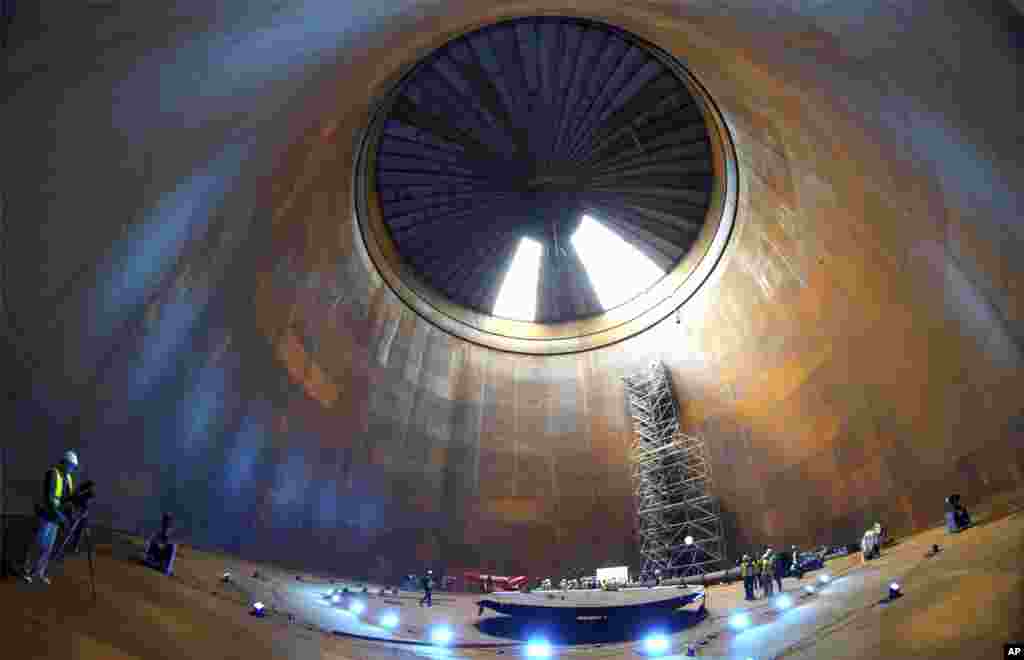 Journalist are seen inside a vast thermal tank to store hot water in Berlin, Germany. Power provider Vattenfall unveiled a new facility that turns solar and wind energy into heat, which can be stored in a vast thermal tank and released into the capital's grid as needed, smoothing out the fluctuating supply problem of renewables.