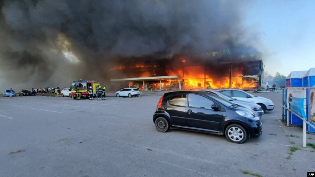 Esta fotografía tomada y publicada por el Servicio Estatal de Emergencias de Ucrania el 27 de junio de 2022 muestra a los bomberos apagando el fuego en un centro comercial afectado por un ataque con misiles rusos en Kremenchuk, que mató al menos a dos personas e hirió a decenas más.