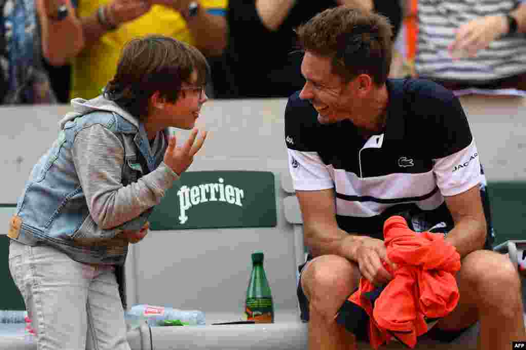 France's Nicolas Mahut celebrates with his son after winning against Italy's Marco Cecchinato during their men's singles first round match on day 1 of The Roland Garros 2019 French Open tennis tournament in Paris.