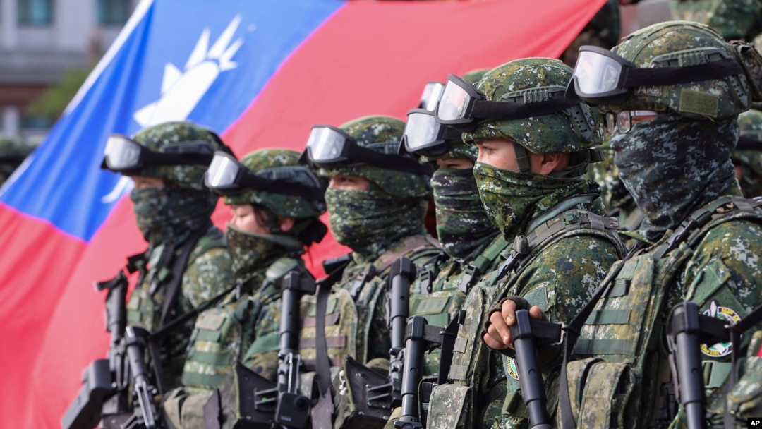 FILE - Soldiers pose for group photos with a Taiwanese flag after a preparedness enhancement drill simulating the defense against Beijing's military intrusions, ahead of the Lunar New Year in Kaohsiung City, Taiwan, on Jan. 11, 2023.