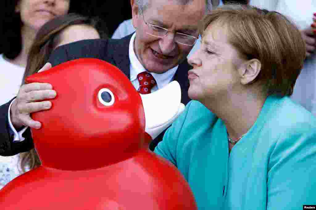 German Chancellor Angela Merkel receives a duck toy as she visits biotech company Centogene in Rostock, Germany.