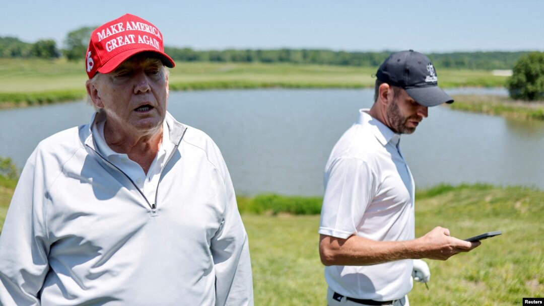 El expresidente de Estados Unidos, Donald Trump (izq.), habla con los reporteros mientras él y su hijo Eric Trump participan en el torneo Pro-Am antes del LIV Golf Invitational en el Trump National Golf Club en Sterling, Virginia, EEUU., el 25 de mayo de 2023.