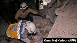 SYRIA -- Syrian rescuers, known as White Helmets, recover bodies in Zardana, in the mostly rebel-held northern Syrian Idlib province, following air strikes in the area, June 7, 2018