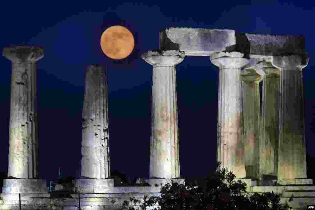 June's full moon, known as the Strawberry Moon, rises above the Apollo Temple in ancient Corinth, Greece, June 17, 2019.
