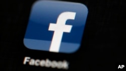 FILE - The Facebook logo is displayed on an iPad in a May 16, 2012 illustration photo. The social media giant says it is banning foreign ads related to Ireland's abortion referendum, amid concerns that North American groups are trying to influence the cam