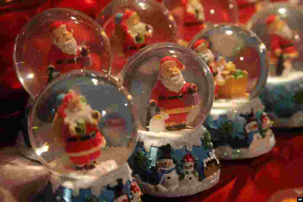 Santa Claus snow globes are displayed at the Christmas market along the Champs Elysees avenue in Paris.