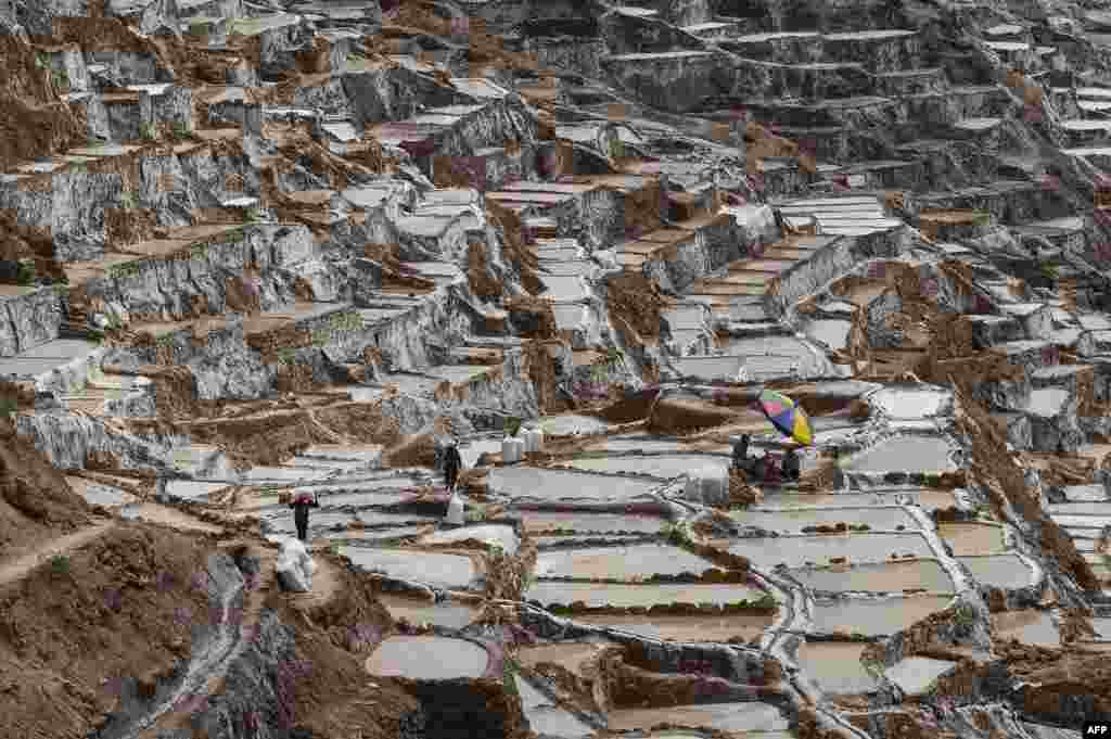 People work at the Maras salt-evaporation ponds, 48 km northeast of Cusco, Peru. Salt pools are one of the tourist attractions in the Cusco area.