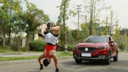 Zhang Shuang, 29, attempts to set a new Guinness World Record for "Fastest time to pull a car 50 metres walking on hands" in Nan Chong City, Sichuan Province, China September 25, 2021. Courtesy of Guinness World Records 2021/Chen Maochao/Handout via REUT