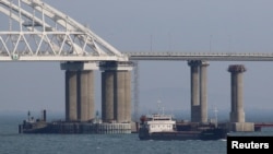 A vessel sails past a bridge connecting Russia with the Crimean Peninsula across the Kerch Strait on November 26, 2018.(Pavel Rebrov/Reuters) 