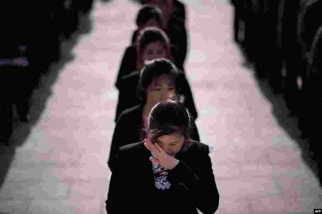 A woman wipes her eyes as she waits to pay her respects before the statues of late North Korean leaders Kim Il Sung and Kim Jong Il, as part of celebrations marking the anniversary of the birth of Kim Il Sung, known as the 'Day of the Sun,' on Mansu hill in Pyongyang, April 15, 2019.
