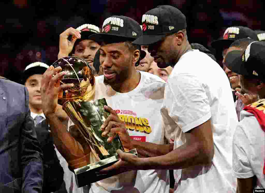 Toronto Raptors forward Kawhi Leonard (2) and Toronto Raptors center Serge Ibaka (9) celebrate with the Larry O'Brien Trophy after the Golden State Warriors in game six of the 2019 NBA Finals at Oracle Arena, Oakland, CA., June 13, 2019. (Kyle Terada-USA Today Sports)