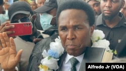 Venâncio Mondlane ergue uma bíblia e faz juramento simbólico como "Presidente eleito pelo povo", Maputo, Moçambique, 9 janeiro 2025