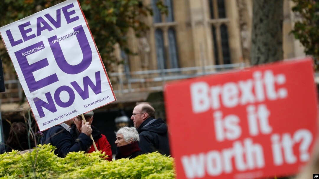 Pro and anti Brexit protesters hold placards as they vie for media attention near Parliament in London, Nov. 16, 2018. Britain's Prime Minister May still faces the threat of a no-confidence vote, after several Conservative Party lawmakers said they had wr